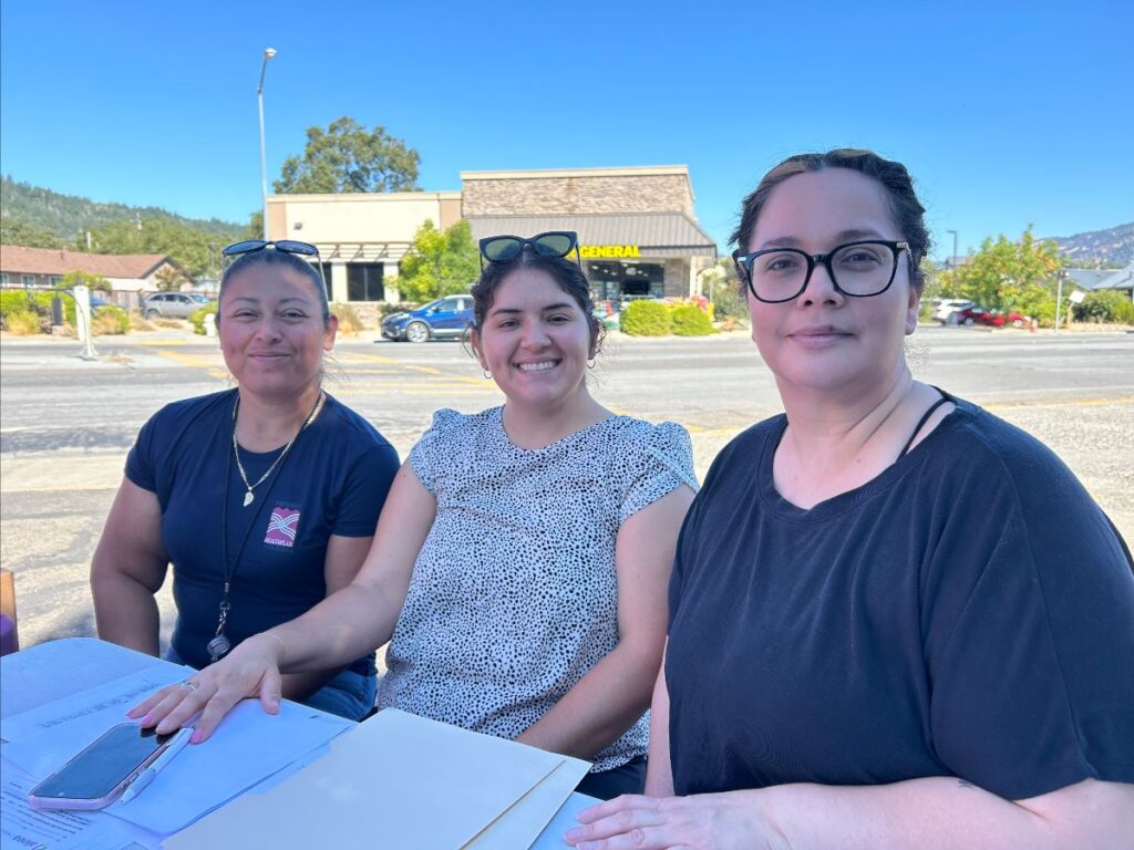 Three woman sitting at a table closely